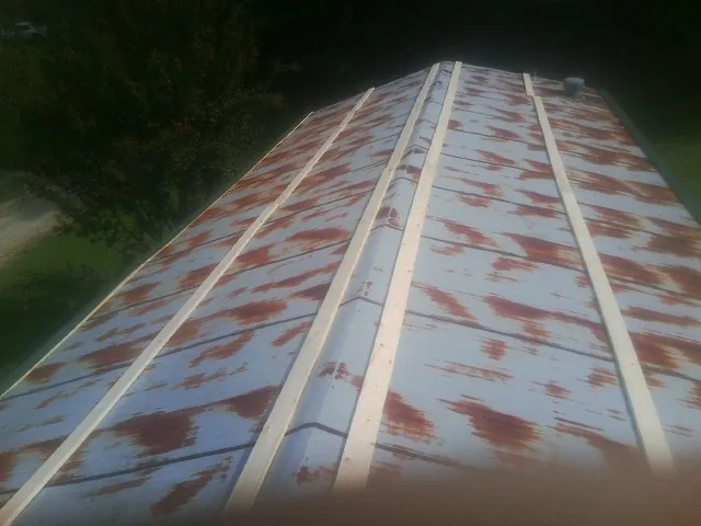 Rusted metal roof panels with new wood purlins before replacement — Storm Damage Roof Repair in Lenni by Roofing Brothers