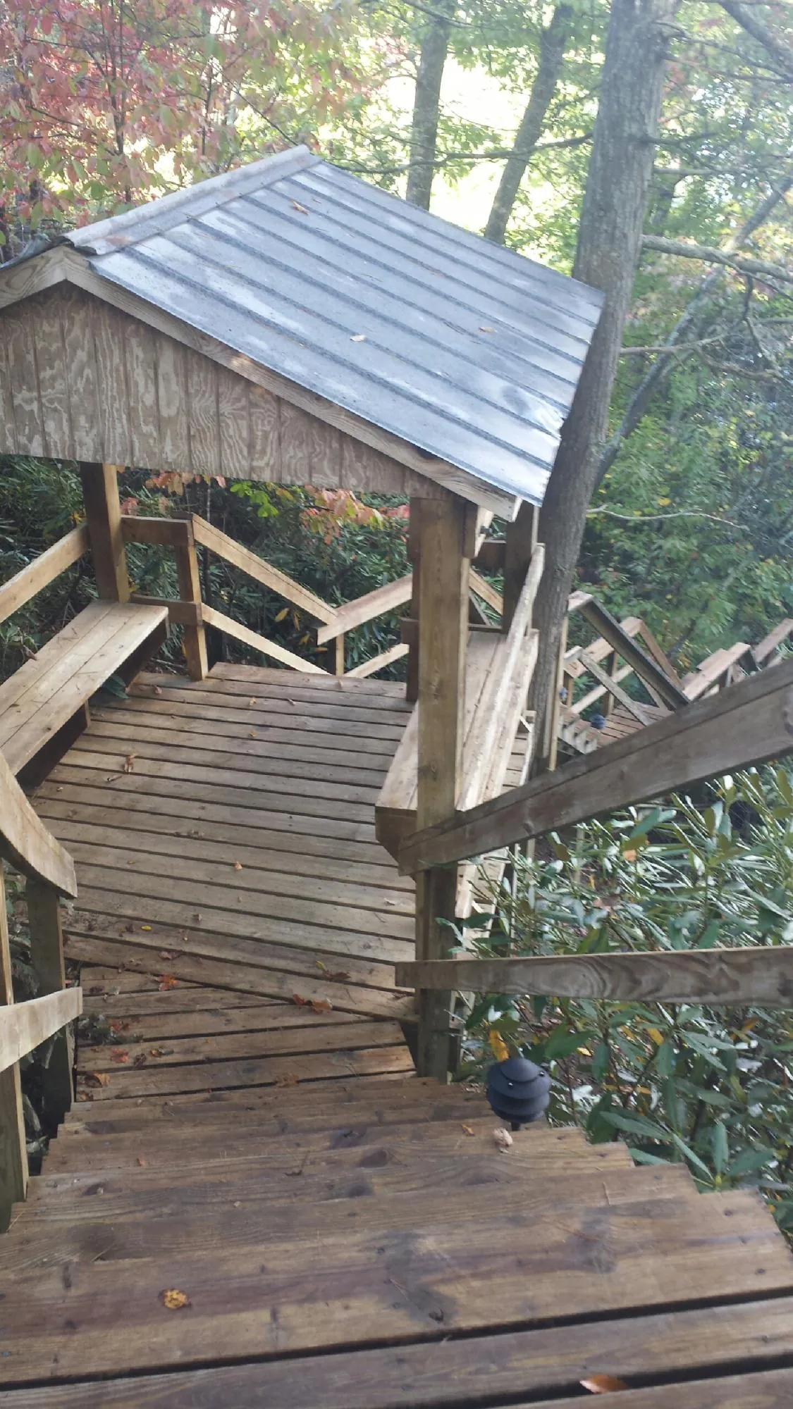 Metal roofed shelter over wooden steps on a wooded walkway — Skylight Repair & Installation work by our crew in Lenni