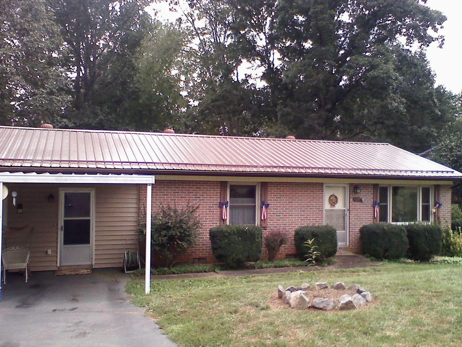 Bronze metal roof and carport on a brick ranch home — Roof Repair work by our crew in Lenni